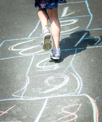 Kinder im sonnigen grünen Garten auf einer Schaukel